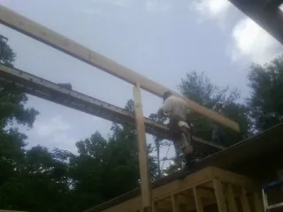 Carpenter setting a ridge beam over a new addition frame — Ice Dam Removal by Roofing Brothers in Knotts Island