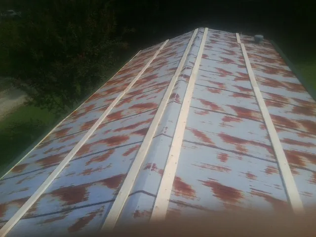 Rusted metal roof panels with new wood purlins before replacement — Storm Damage Roof Repair in Knotts Island by Roofing Brothers