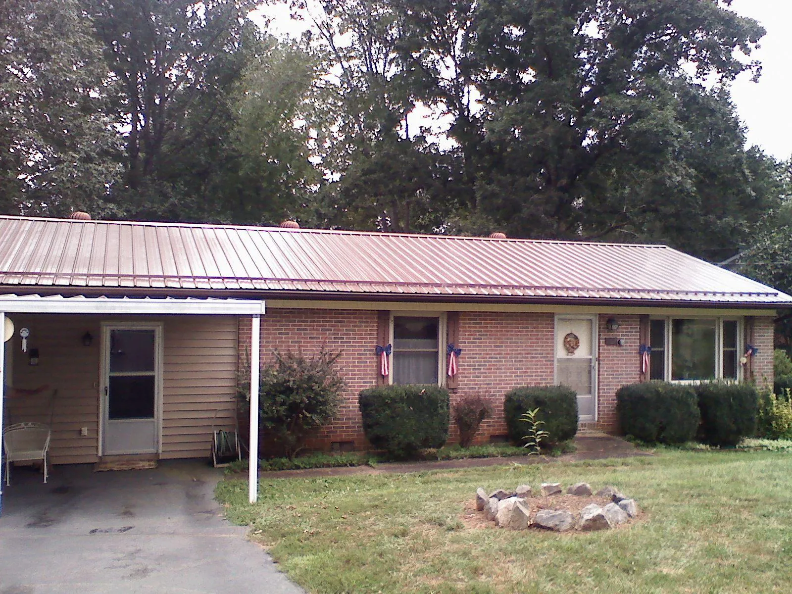 Bronze metal roof and carport on a brick ranch home — Roof Repair work by our crew in Knotts Island